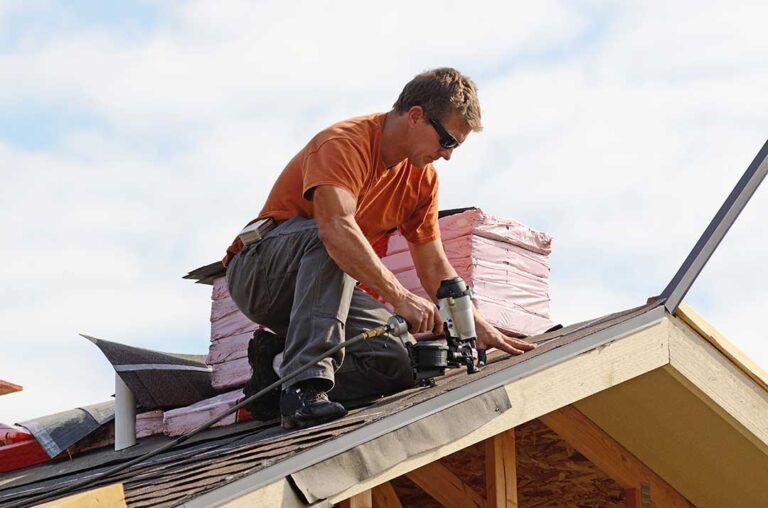 Person inspecting roof edges with binoculars, gloves, flashlight, ladder, and hand tools nearby.